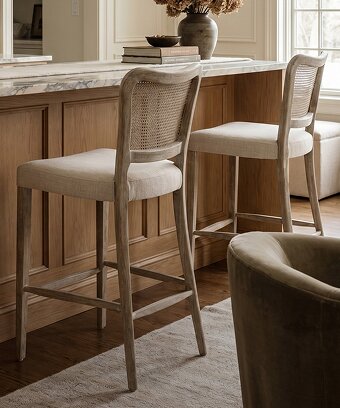 Woven counter stool beside a dark kitchen island